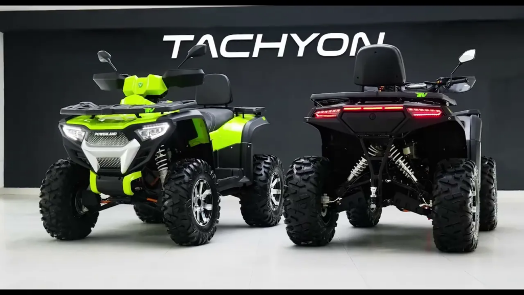 To elektriske Powerland Tachyon-ATV'er fotograferet forfra og bagfra i et moderne showroom.